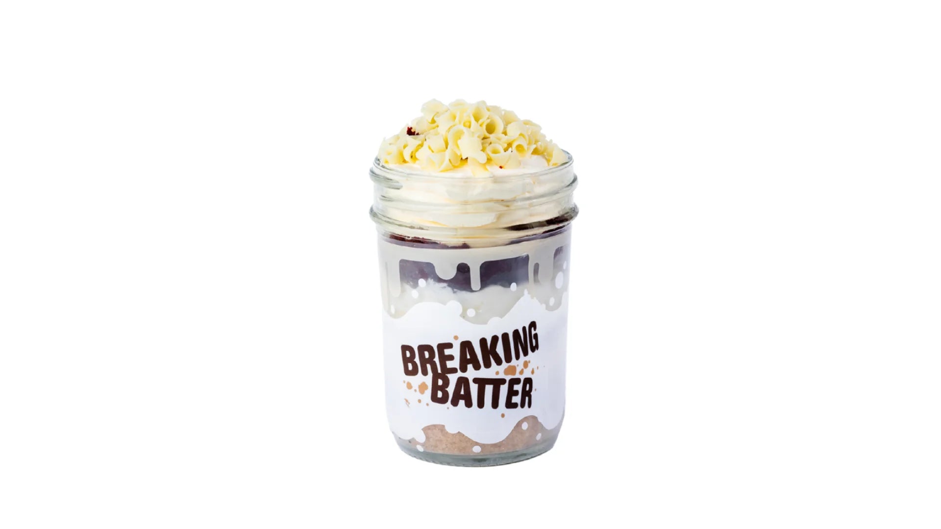 A Breaking Batter Cake Jar with Red Velvet Cake, Cream Cheese Frosting and White Chocolate Curls.