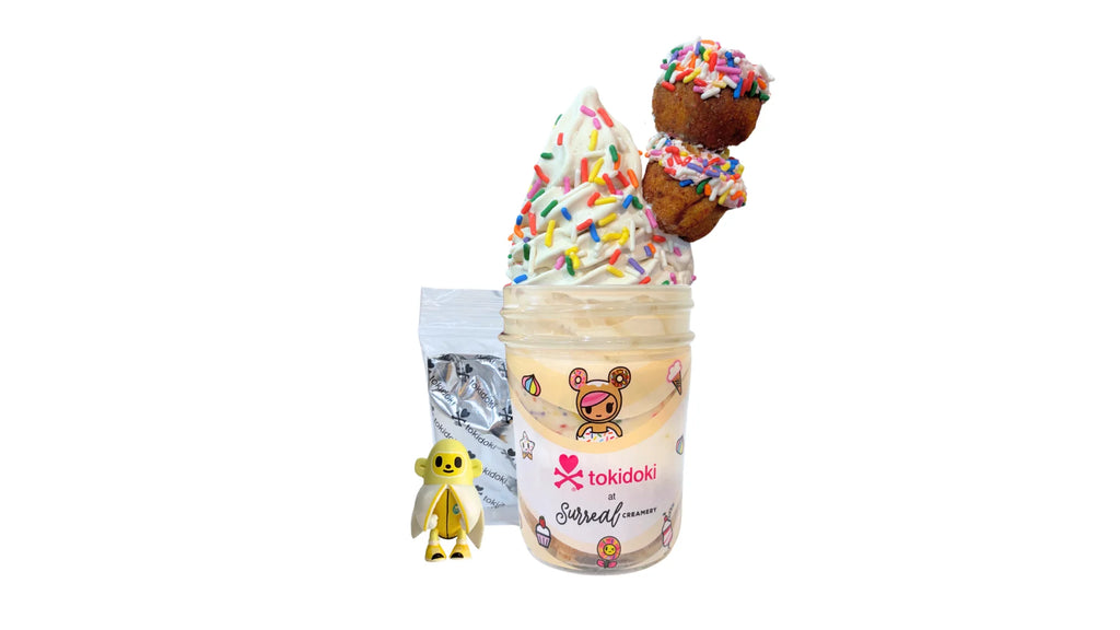 A tokidoki inspired Breaking Batter Ice Cream Cake Jar with Tres Leches Vanilla Cake, Strawberry Frosting, Rainbow Sprinkles, Earl Grey Ice Cream and 2 Frosted Holes with Rainbow Sprinkles. Served in a limited-edition mason jar and paired with one 1" tokidoki mystery collectible.