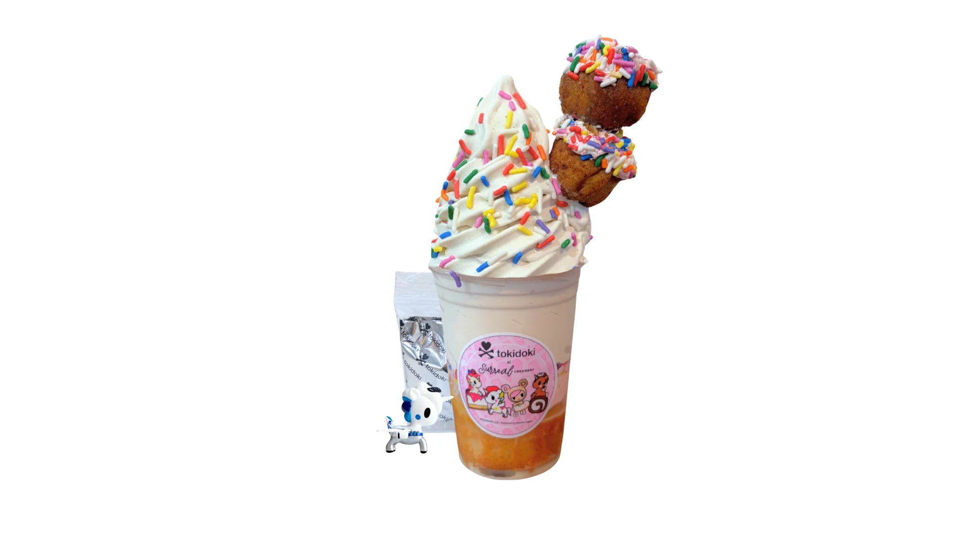 A tokidoki inspired Breaking Batter Ice Cream Cake Cup with Tres Leches Vanilla Cake, Strawberry Frosting, Rainbow Sprinkles, Earl Grey Ice Cream and 2 Frosted Holes with Rainbow Sprinkles. Comes paired with one 1" tokidoki mystery collectible.