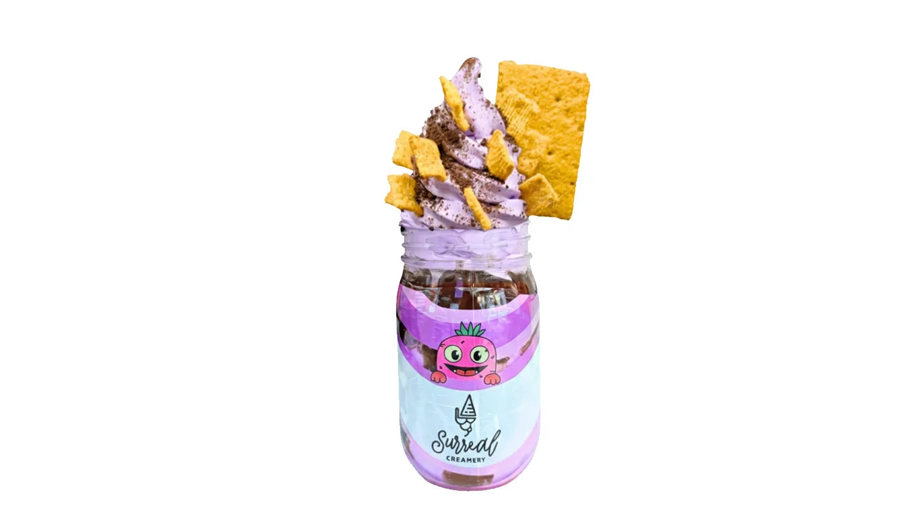 Surreal Creamery Know Your Roots Ice Cream Mason Jar with Taro Ice Cream, Cinnamon Toast Crunch, Chocolate Crunch, Chocolate Syrup, and a Cinnamon Graham Cracker.