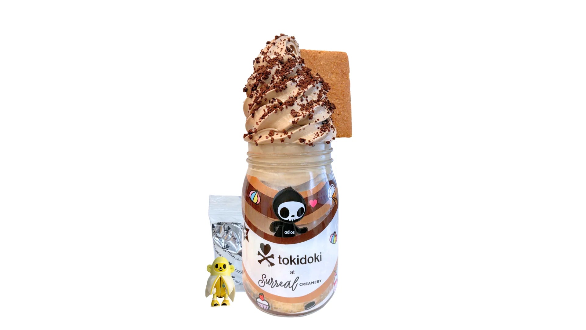 A tokidoki inspired Breaking Batter Ice Cream Cake Jar with Vanilla Cake, Chocolate & Marshmallow Whipped Frosting, Graham Crackers, Chocolate Chips, Chocolate Crunch and Chocolate Ice Cream. Served in a limited-edition mason jar and paired with one 1" tokidoki mystery collectible.