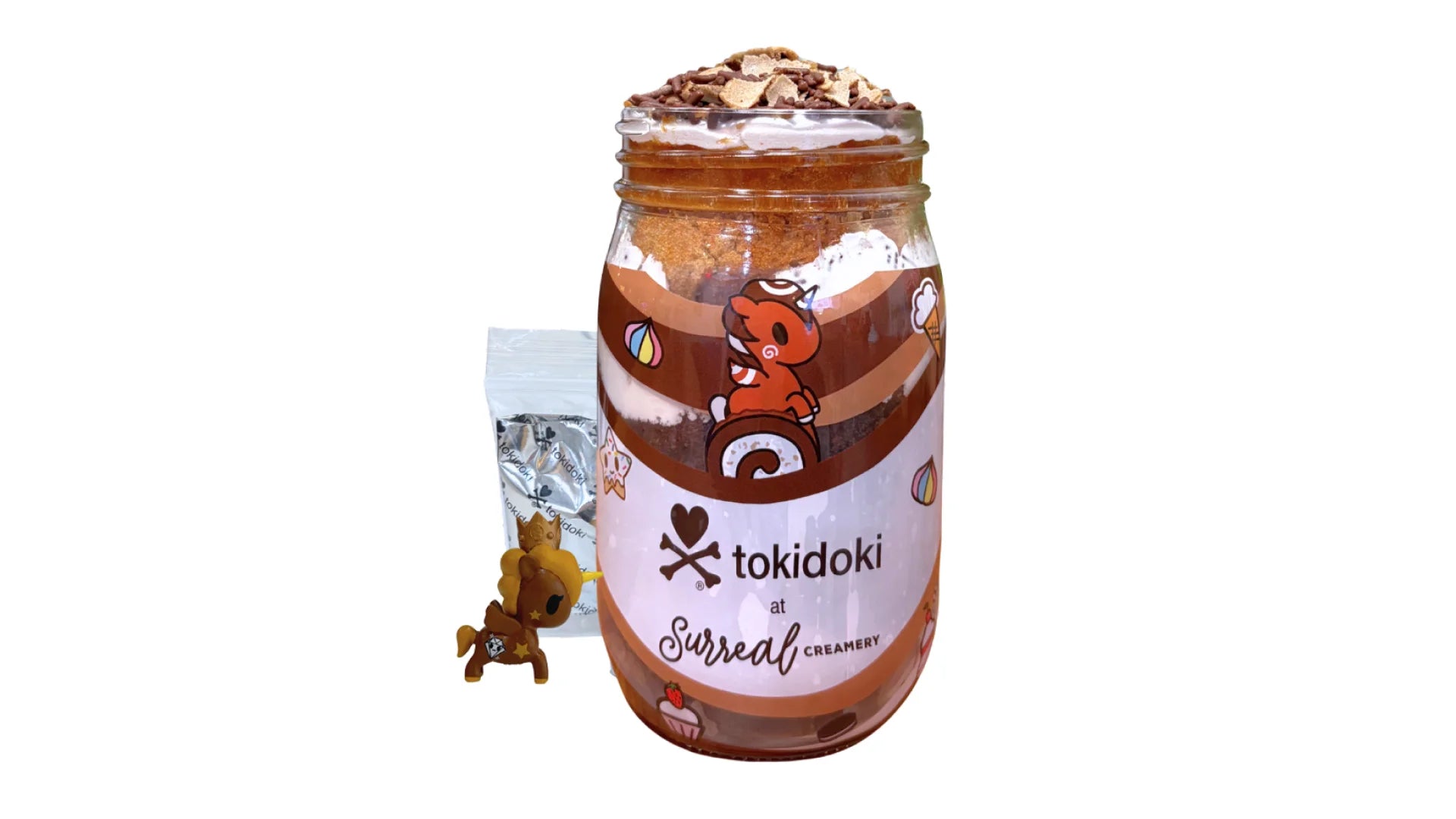 A tokidoki inspired Breaking Batter Cake Jar with Chocolate Cake, Espresso Cake, Chocolate & Marshmallow Whipped Frosting, Chocolate Sprinkles and Chocolate Straws. Served in a limited-edition mason jar and paired with one 1" tokidoki mystery collectible.