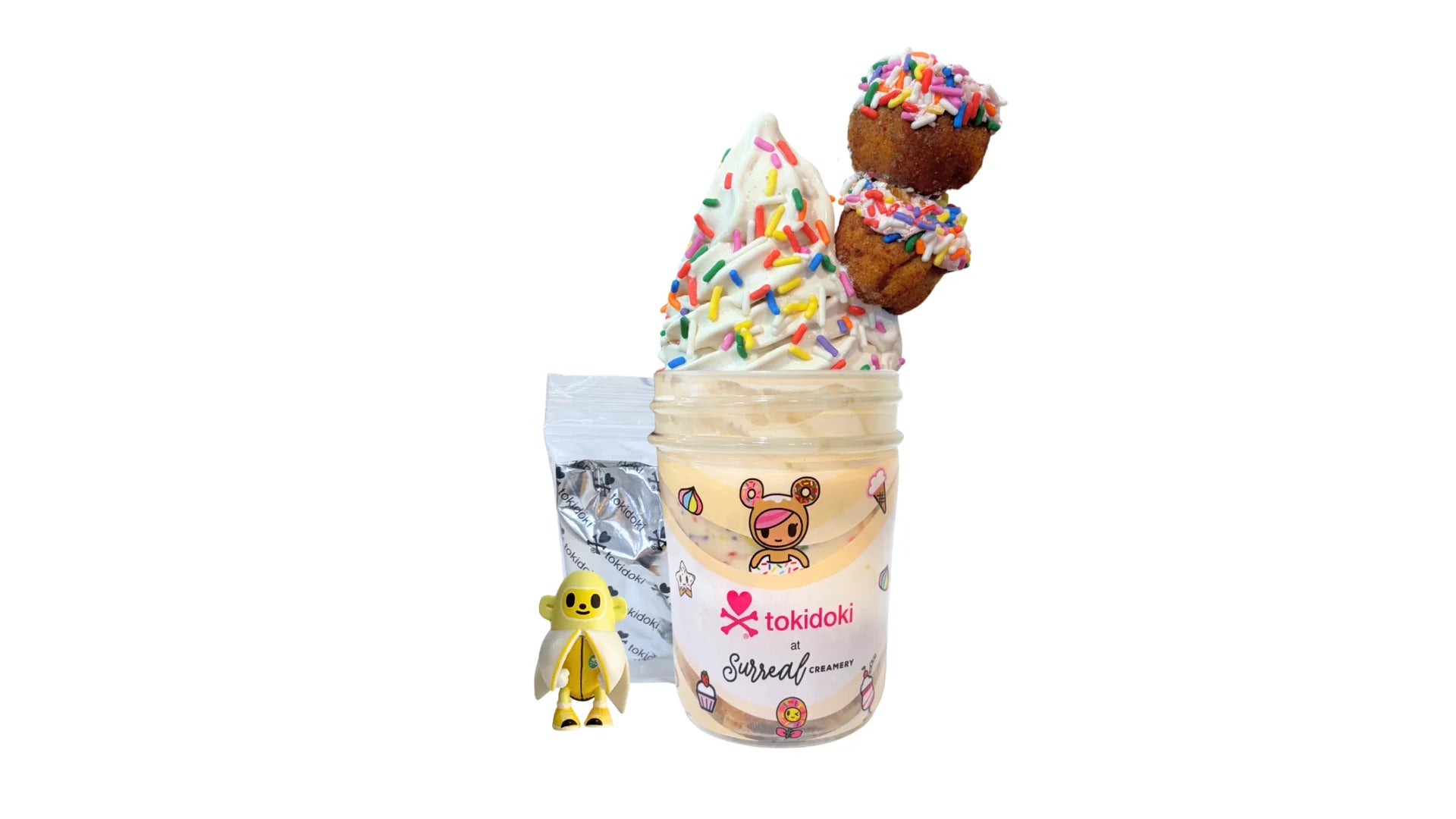 A tokidoki inspired Breaking Batter Ice Cream Cake Jar with Tres Leches Vanilla Cake, Strawberry Frosting, Rainbow Sprinkles, Earl Grey Ice Cream and 2 Frosted Holes with Rainbow Sprinkles. Served in a limited-edition mason jar and paired with one 1" tokidoki mystery collectible.