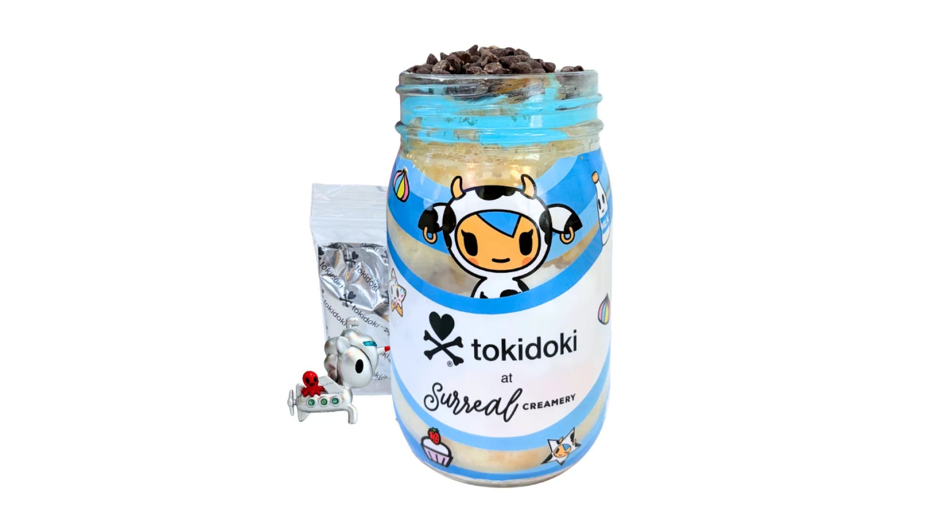 A tokidoki inspired Breaking Batter Cake Jar with Vanilla Cake, Cookies and Cream & Blue Vanilla Frosting, Chocolate Chips and Whipped Cream. Served in a limited-edition mason jar and paired with one 1" tokidoki mystery collectible.