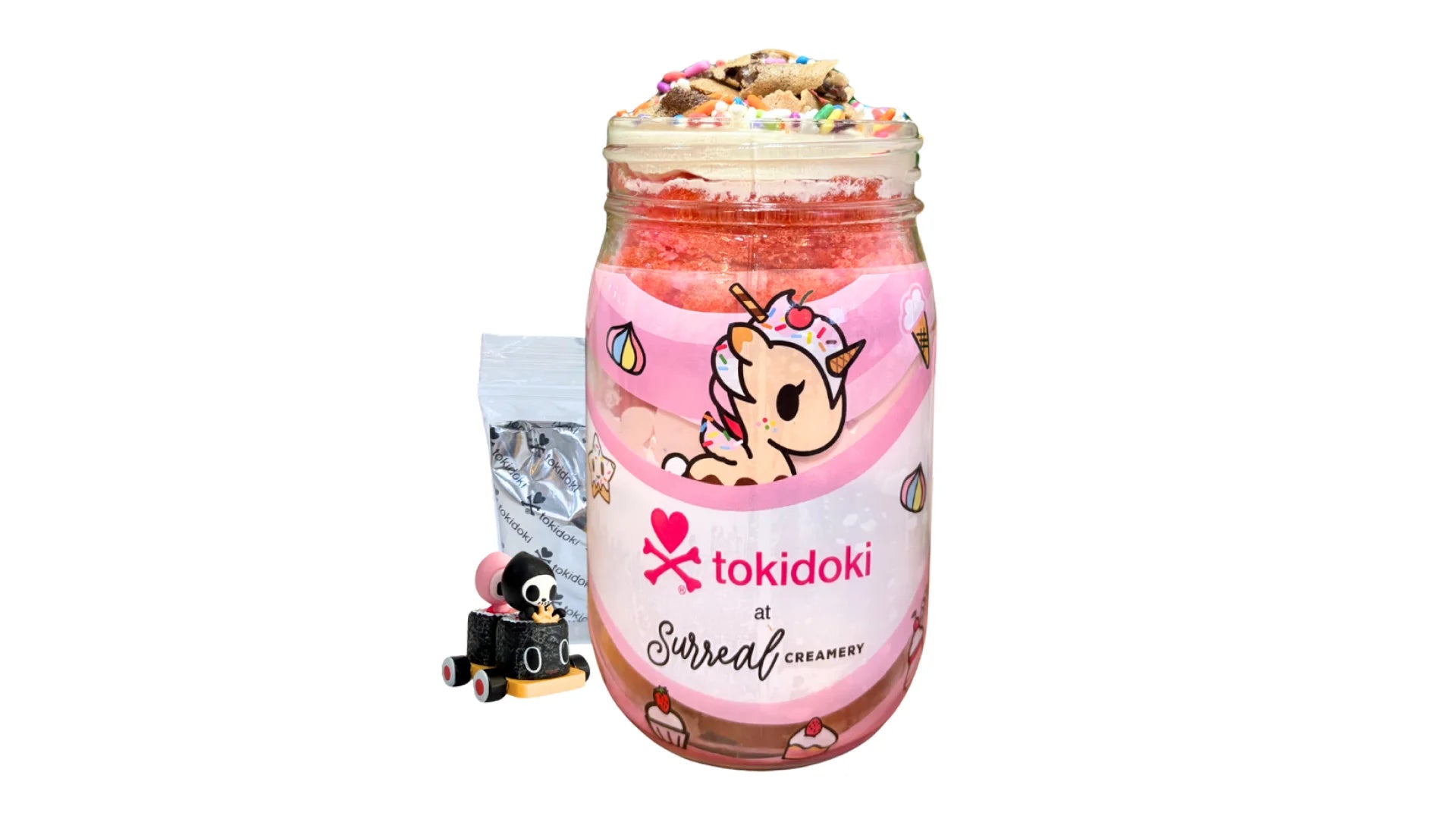 A tokidoki inspired Breaking Batter Cake Jar with Vanilla Cake, Strawberry Cake, Cream Cheese Frosting, Rainbow Sprinkles and Chocolate Straws. Served in a limited-edition mason jar and paired with one 1" tokidoki mystery collectible.