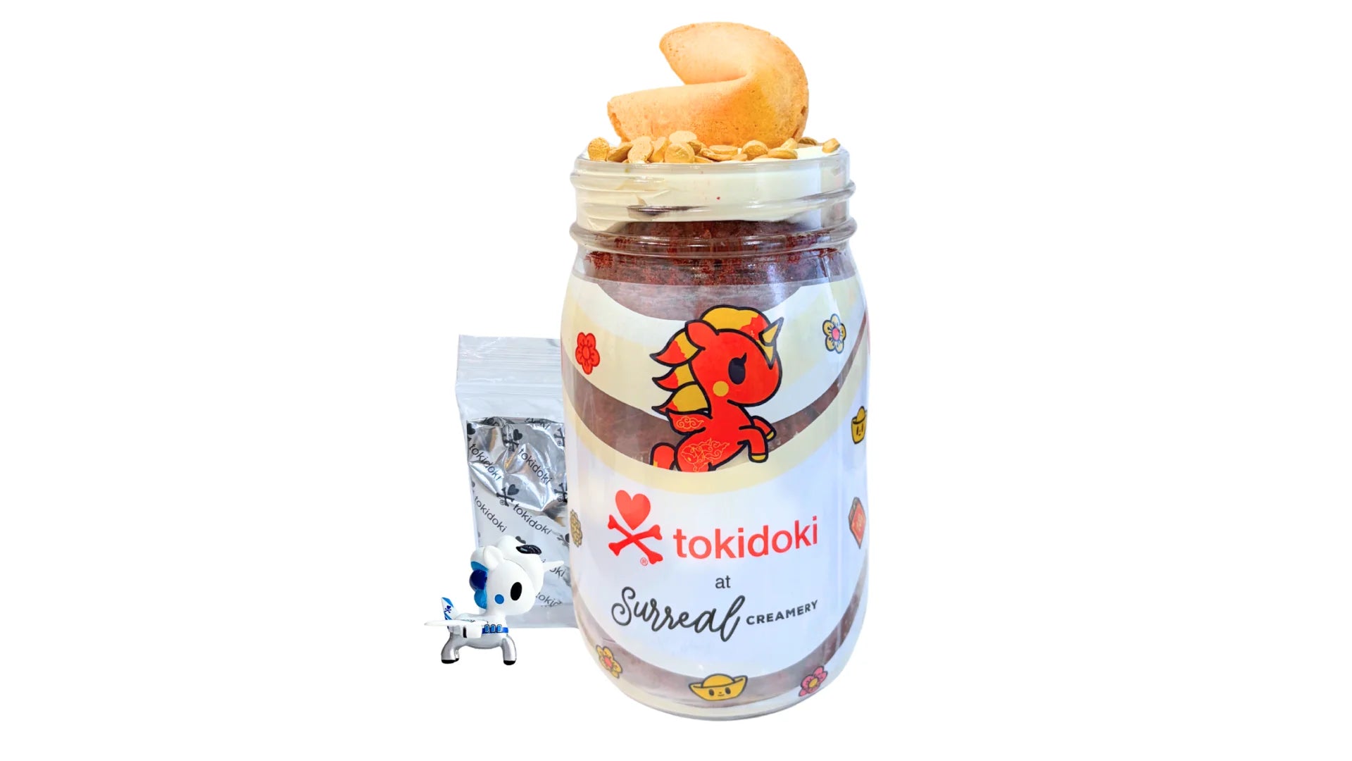 A tokidoki inspired Breaking Batter Cake Jar with Red Velvet Cake, Cream Cheese Frosting, Golden Sprinkles and a Fortune Cookie. Served in a limited-edition mason jar and paired with one 1" tokidoki mystery collectible.